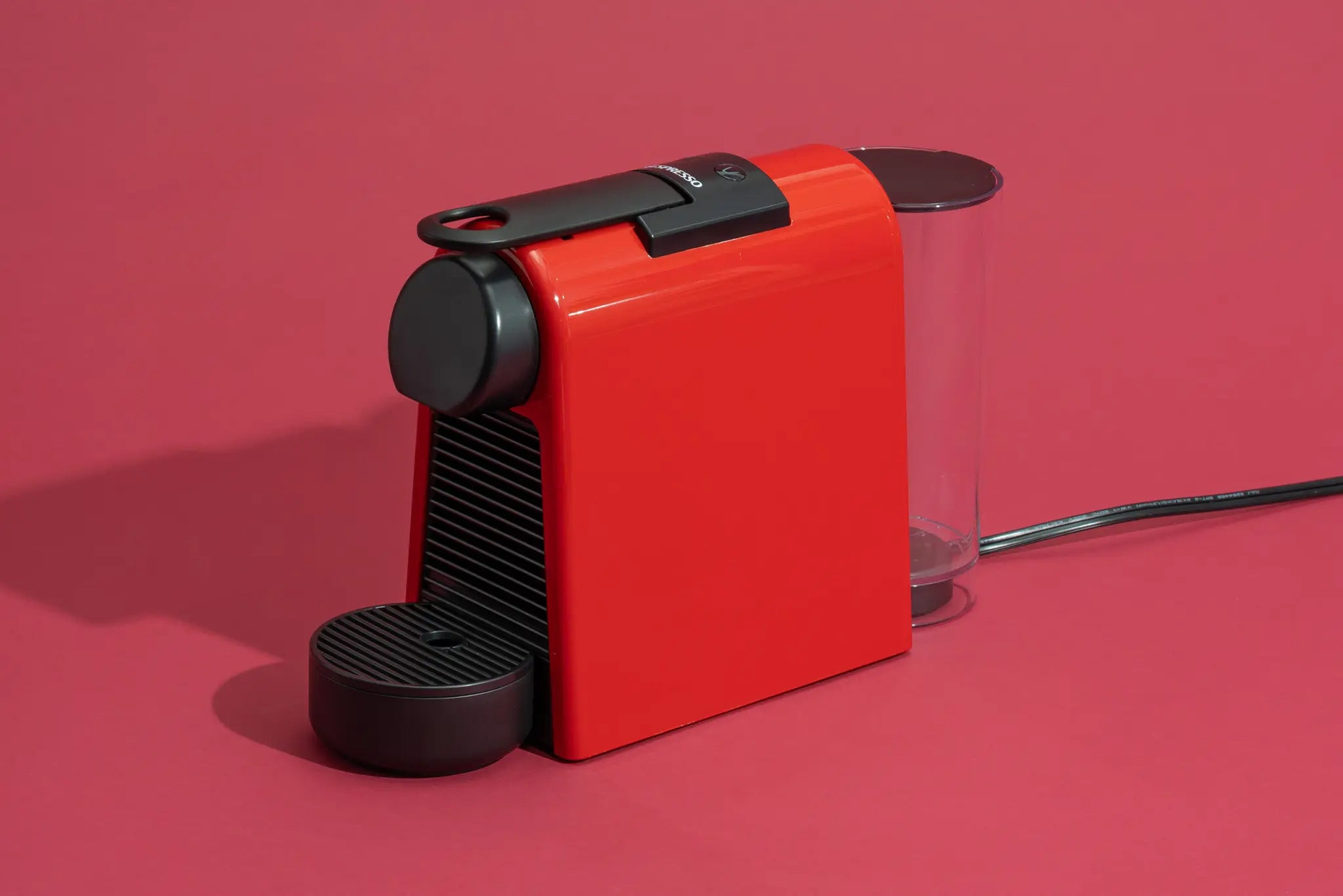Nespresso Essenza Mini in red, a compact espresso machine ideal for dorm rooms.