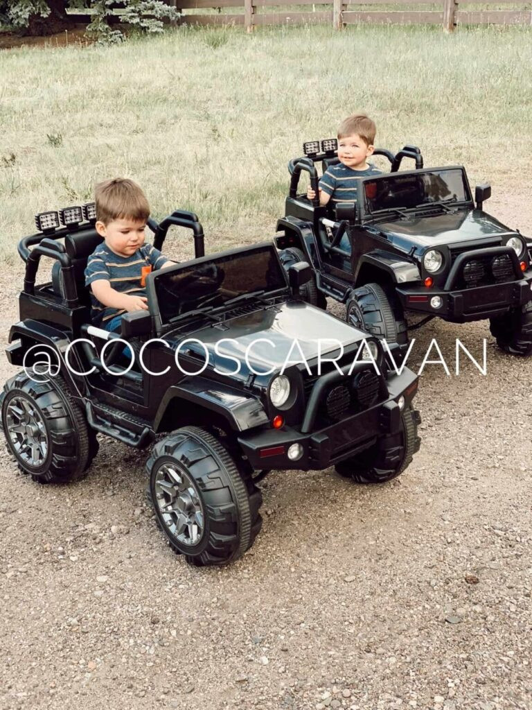 Child riding a black Jeep ride-on car outdoors