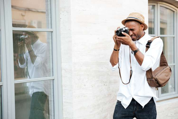 Man taking photos with a vintage film camera in an urban setting