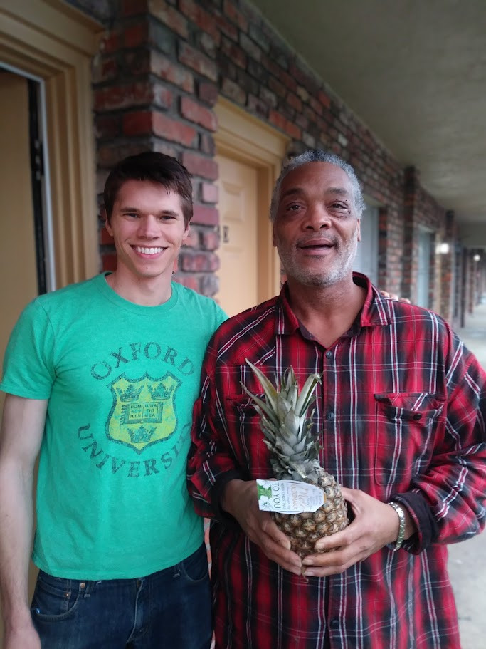 A fresh pineapple with a ribbon and a tag, presented as a Christmas gift.