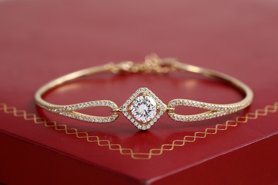 Gold bracelet with diamond pendant on a red box