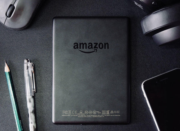A person reading an ebook on a Kindle device, showcasing digital reading with Amazon Gift Cards.