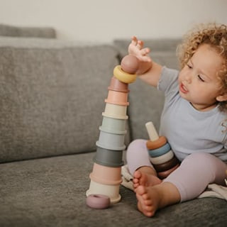 Mushie Stacking Cups Toy, a set of colorful stacking cups in pastel shades, made in Denmark