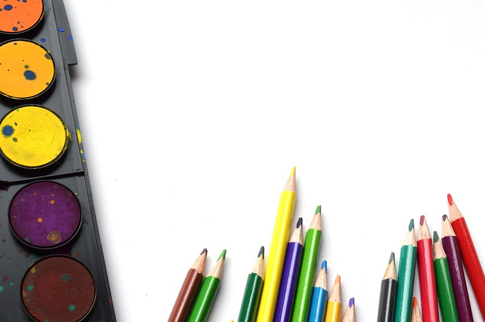 Colored pencils and paints to represent an adult coloring book as a great gift idea for mom!