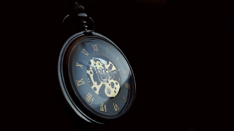 A pocket watch close-up photo with a black background