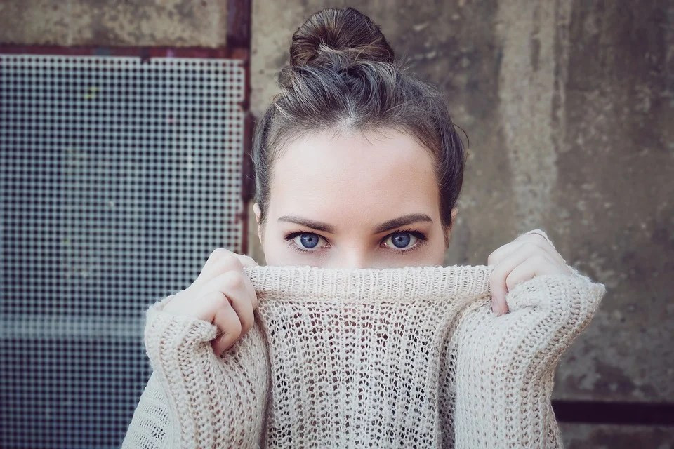 A woman in a beige pullover sweater