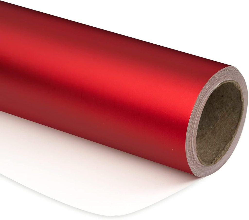 A roll of red metallic adhesive vinyl, perfect for gift wrapping, partially unrolled on a white surface, presenting a modern and durable gift packaging material.