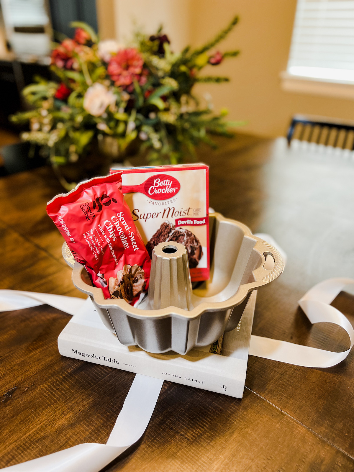 Cake mix and chocolate chips added to a baking themed wedding gift basket