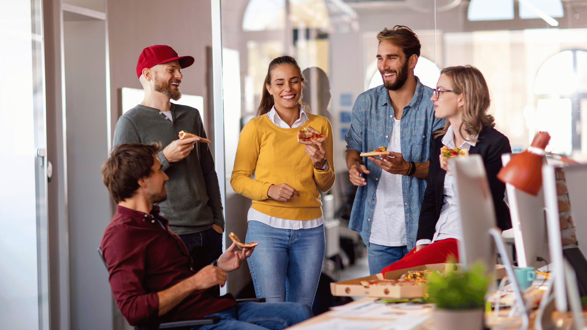 Team enjoying pizza in the office, representing in-person employee appreciation