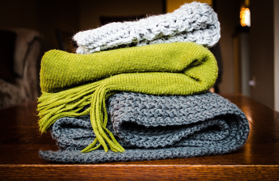 A stack of cozy blankets to symbolize a weighted blanket as a gift idea for mom!