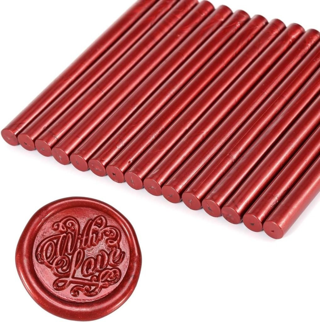 Red wax sticks lined up, with a round wax seal impression featuring the words , showcasing wax seal supplies for elegant gift tag embellishments.