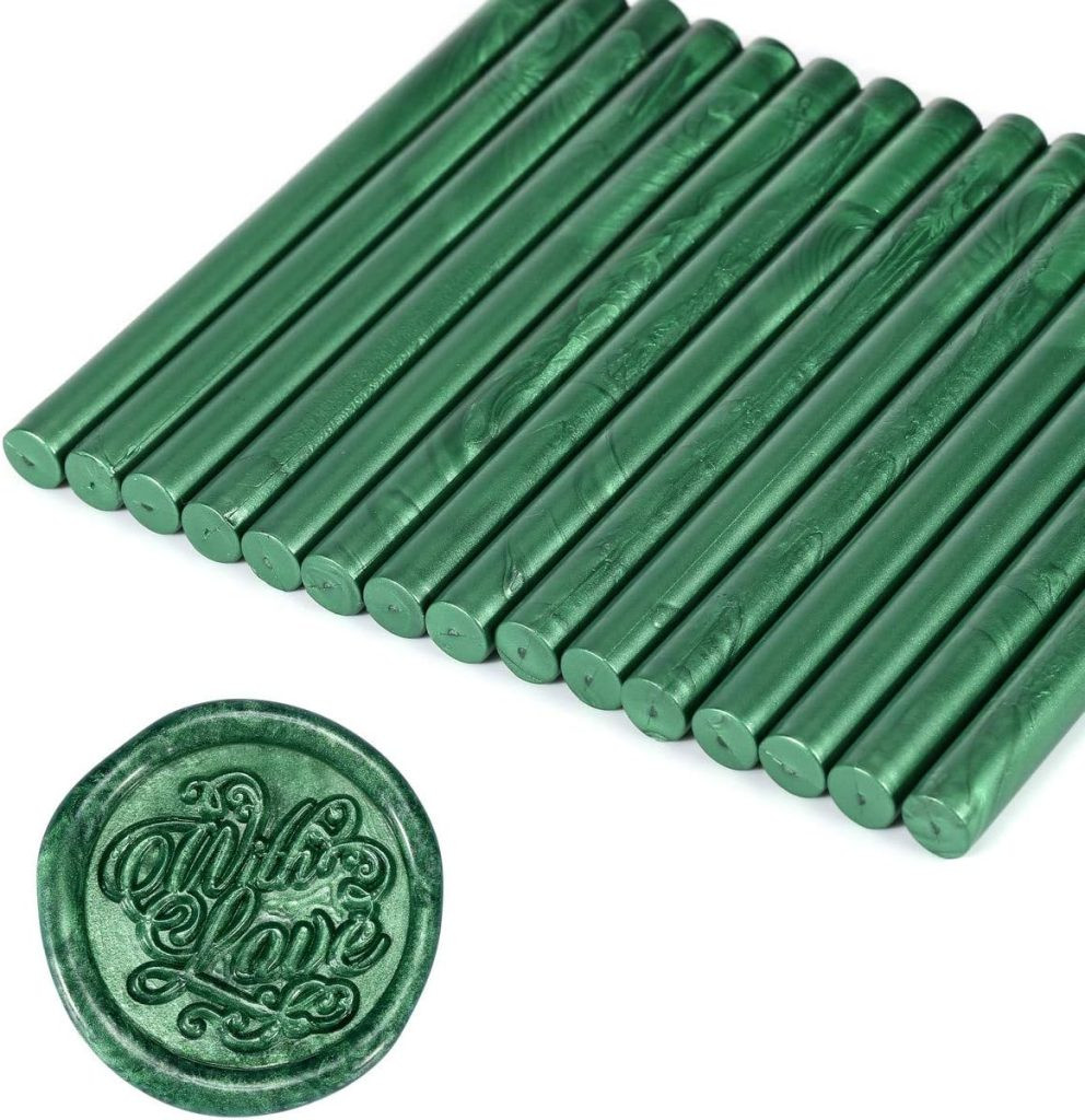 Seventeen green metallic wax sticks are arranged side by side, perfect for gift wrapping. In the foreground, a green wax seal imprint reads , presenting green wax seal options for unique gift tag designs.