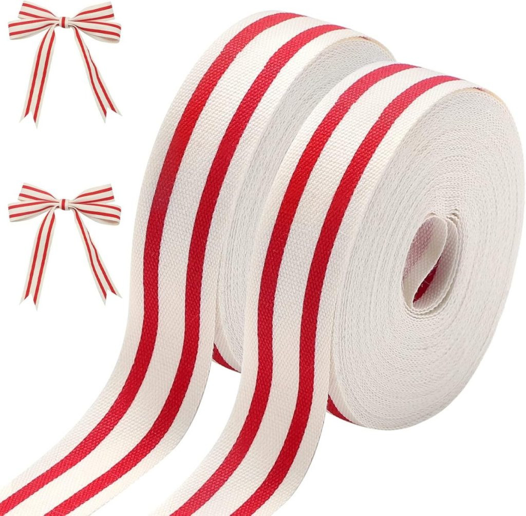 Two rolls of white fabric ribbon with red stripes, perfect for gift wrapping, alongside two tied bows of the same design, displaying striped ribbon for a classic and festive look.