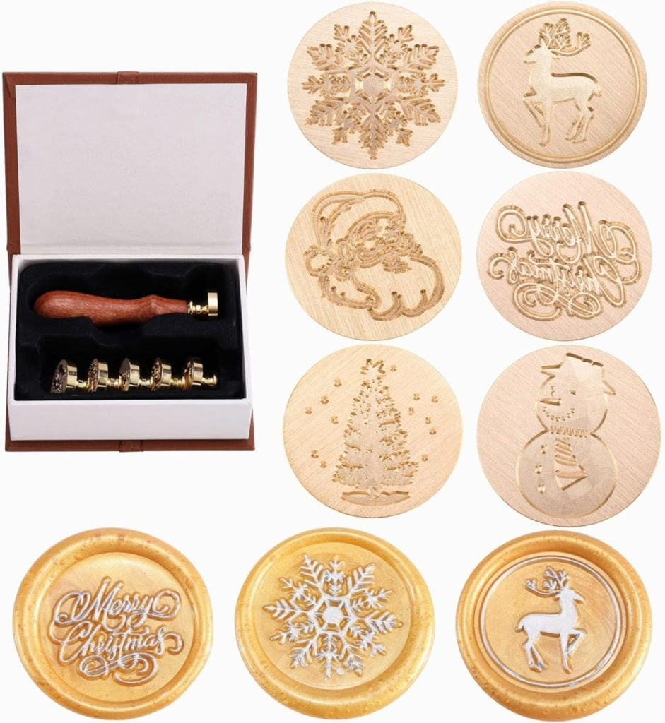A set of wooden stamps with holiday designs, such as a snowflake, reindeer, Santa, tree, and snowman, perfect for adding charm to your gift wrapping. Each stamp leaves a beautiful impression in gold wax, making every present feel extra special, highlighting decorative stamp sets for personalized gift tags.
