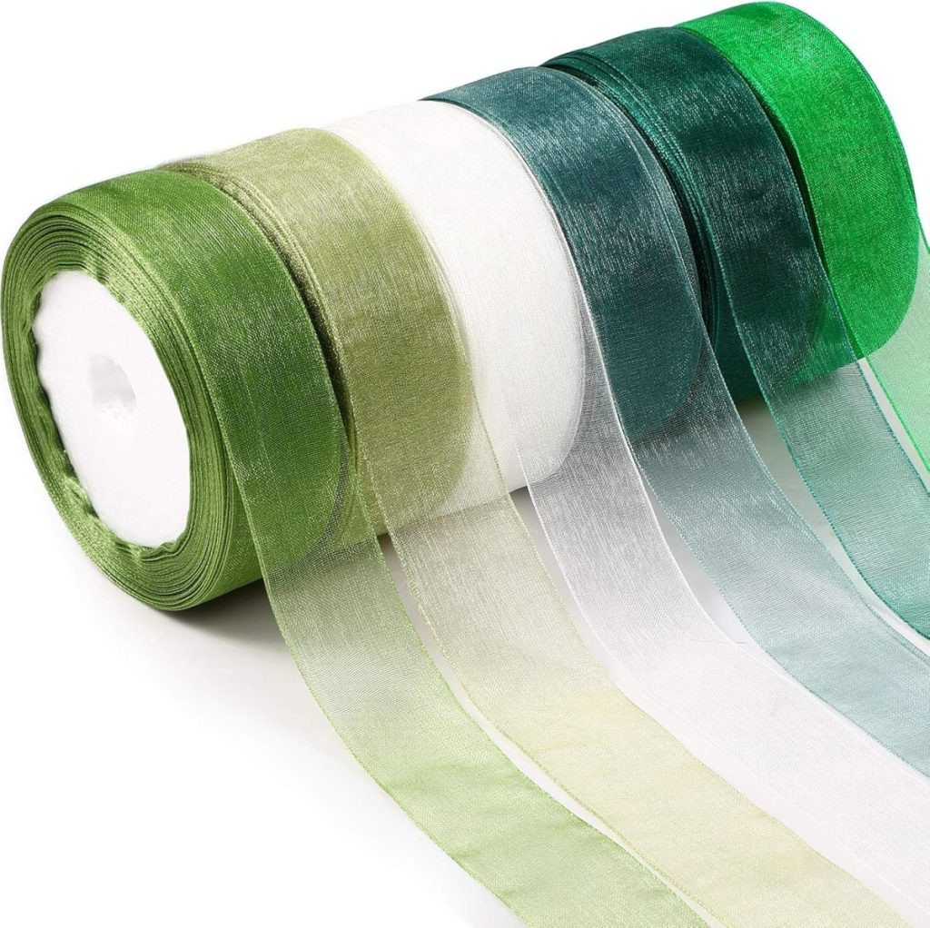 Five rolls of sheer, glossy ribbon in various shades of green and white are displayed in a row, perfect for elegant gift wrapping, showcasing sheer ribbon options for sophisticated gift packaging.