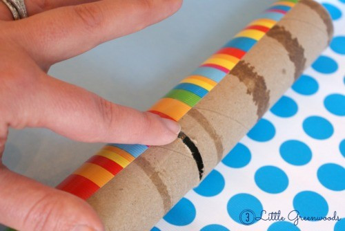 Step 1 in DIY birthday popper tutorial: cutting paper towel roll.