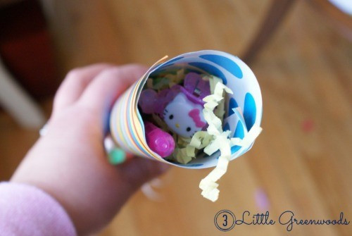 Filling a DIY birthday popper with prizes and candy.