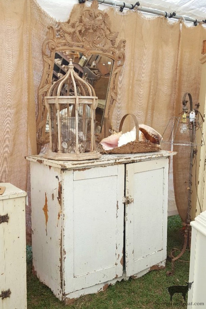 A rustic wooden cabinet filled with vintage items at Renninger's Extravaganza, displaying the warm, aged tones and textures of antique furniture.