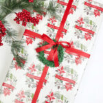Gift wrapped with ribbon and garland pick wreath, showcasing a budget-friendly Christmas gift wrap idea from Dollar Tree.