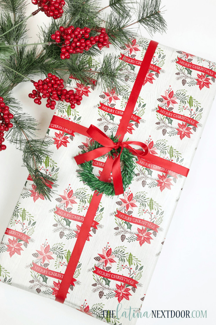 Gift wrapped with ribbon and garland pick wreath, showcasing a budget-friendly Christmas gift wrap idea from Dollar Tree.