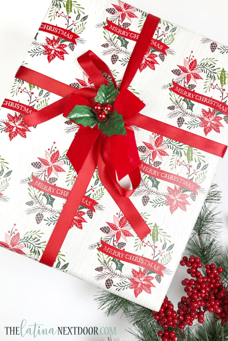 Gift adorned with a bow and sprigs of artificial greenery, demonstrating a simple and affordable Dollar Tree gift wrapping technique.