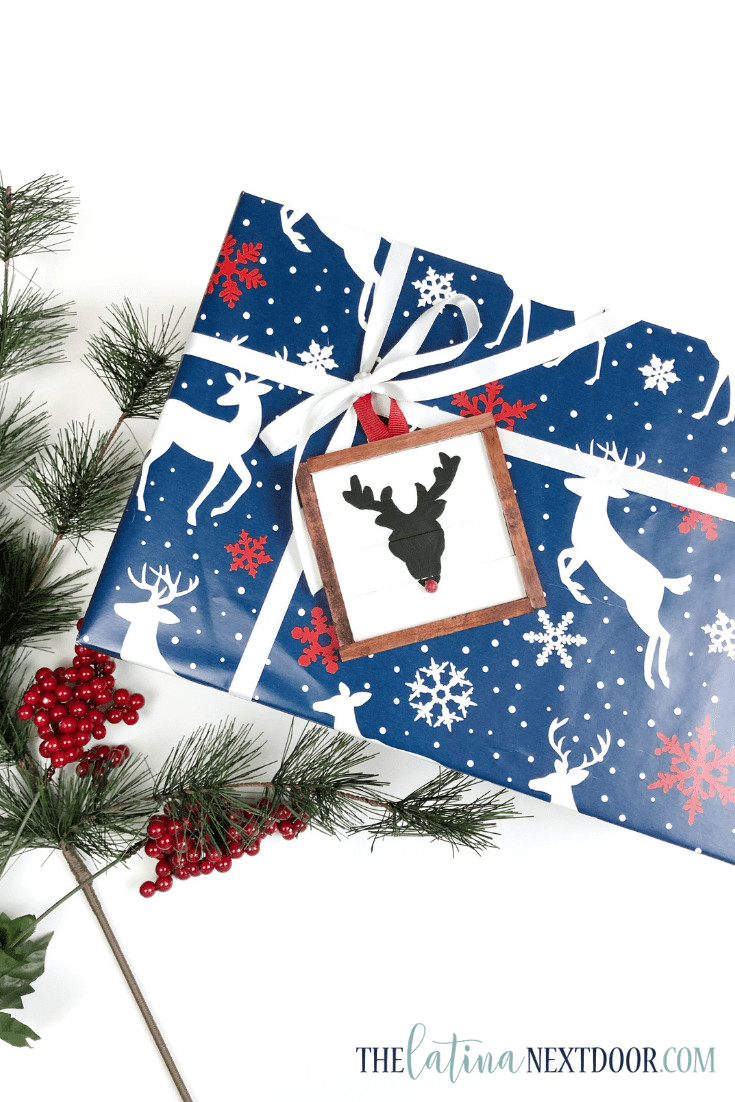 Gift package decorated with a reindeer ornament crafted from popsicle sticks, highlighting a DIY Dollar Tree gift wrap idea.