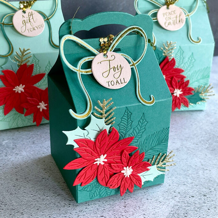 Finished Christmas gift boxes with bows, ribbons, and poinsettia decorations, showcasing the complete ombré set.