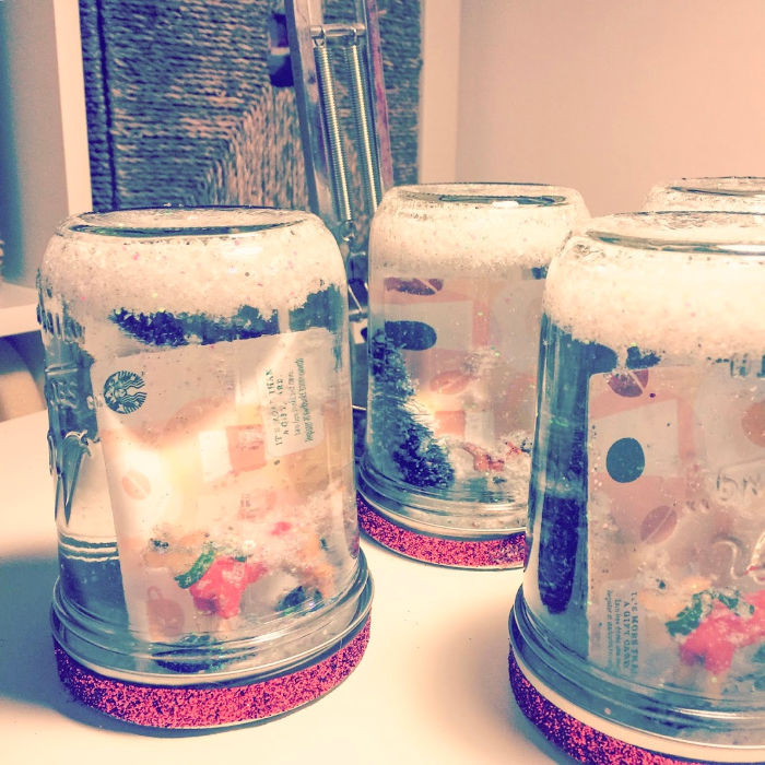 DIY snow globe gift card holder with miniature trees and glitter inside a mason jar, a festive and unique teacher gift.