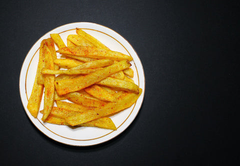 Crispy air fryer french fries in a black air fryer basket, showcasing a healthier cooking appliance.