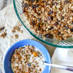 A close-up shot of homemade granola in a clear jar, showcasing the oats, nuts, and seeds.