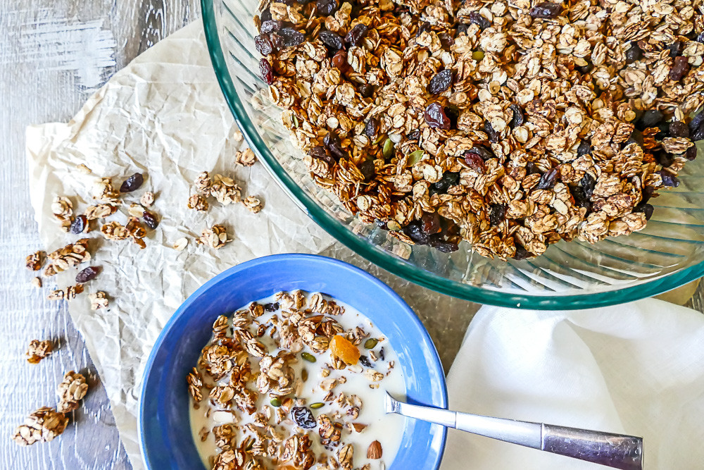 A close-up shot of homemade granola in a clear jar, showcasing the oats, nuts, and seeds.