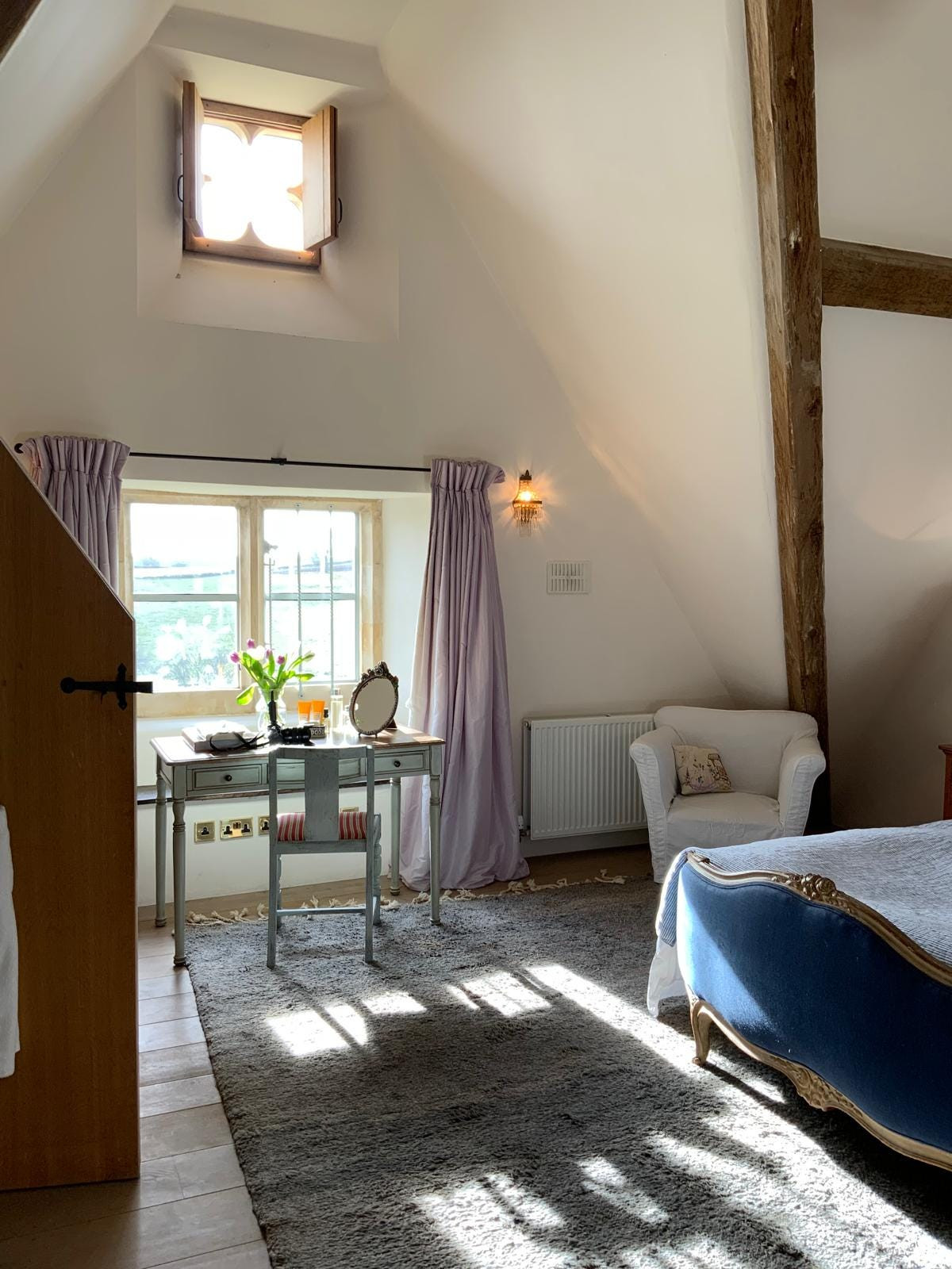 The Lilac Room, a luxurious guest room featuring taffeta ball skirt curtains and exquisite decor, perfect for discerning guests
