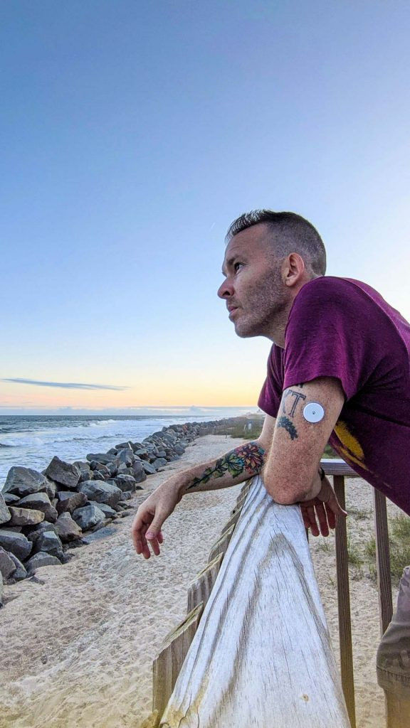 Person with CGM on arm, representing continuous glucose monitoring for diabetes management
