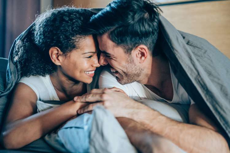 Luxurious new bed linens in a bedroom setting, emphasizing the comfort and indulgence of this gift idea for married couples.