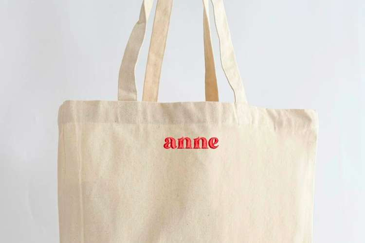 A stylish monogrammed tote bag carried by a young woman, showcasing its practicality and personalized initials
