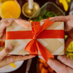 Child receiving a gift, with focus on hands exchanging a wrapped present.