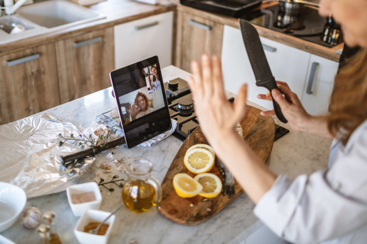 Bridesmaids joyfully participating in an online cooking class, a unique and engaging bridesmaid gift idea.