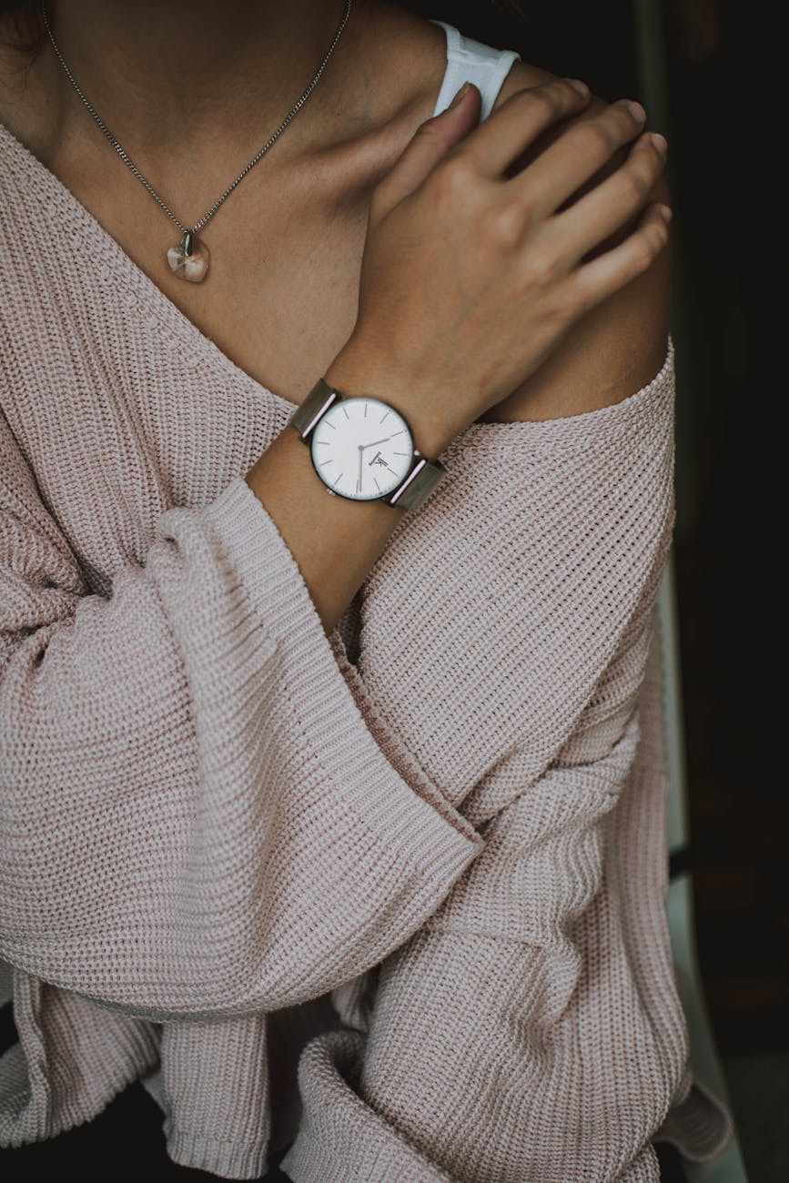 woman wearing beige crochet sweater, necklace and round white analog watch closeup photo