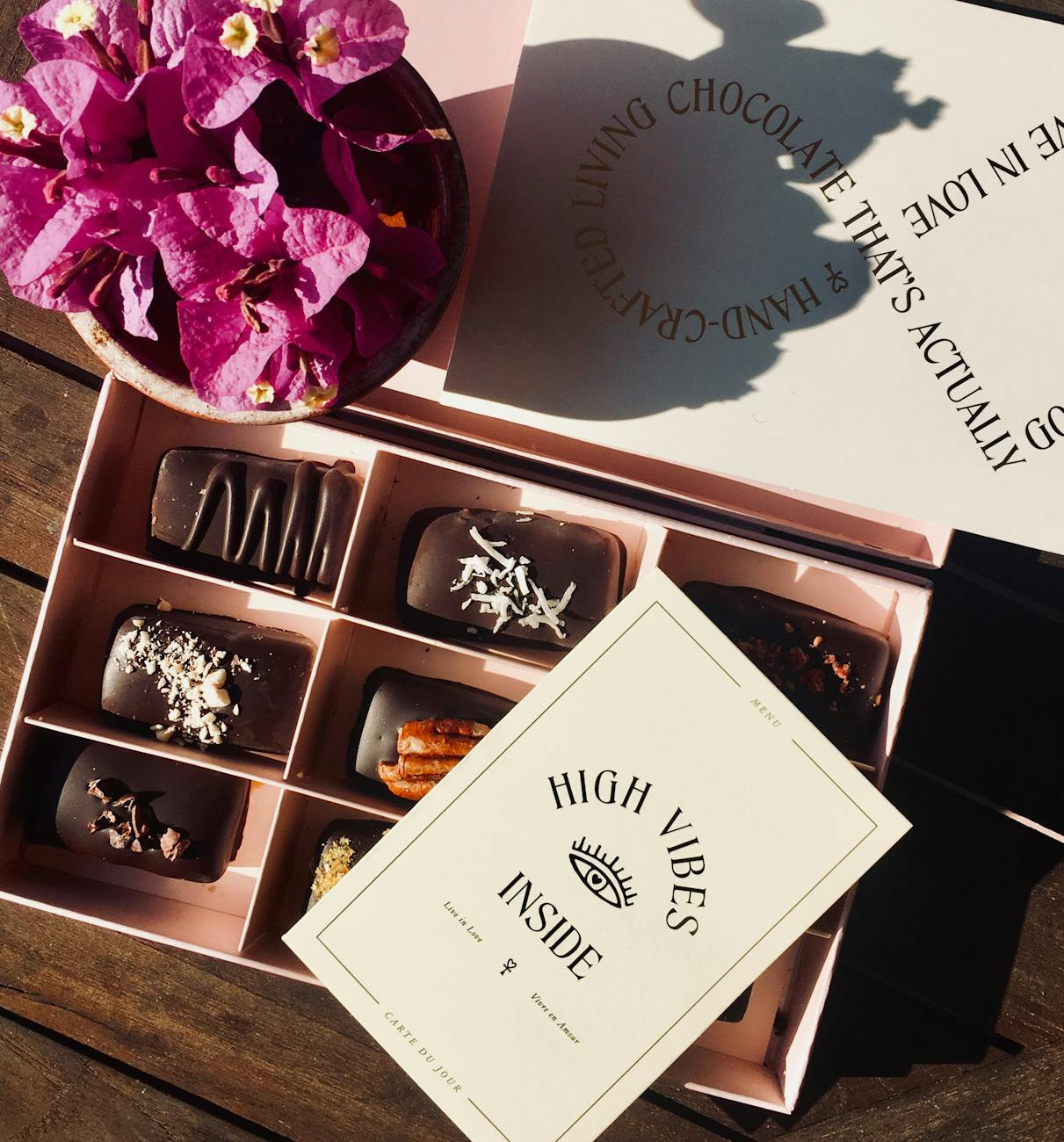 box of chocolates beside bougainvillea flower arrangement
