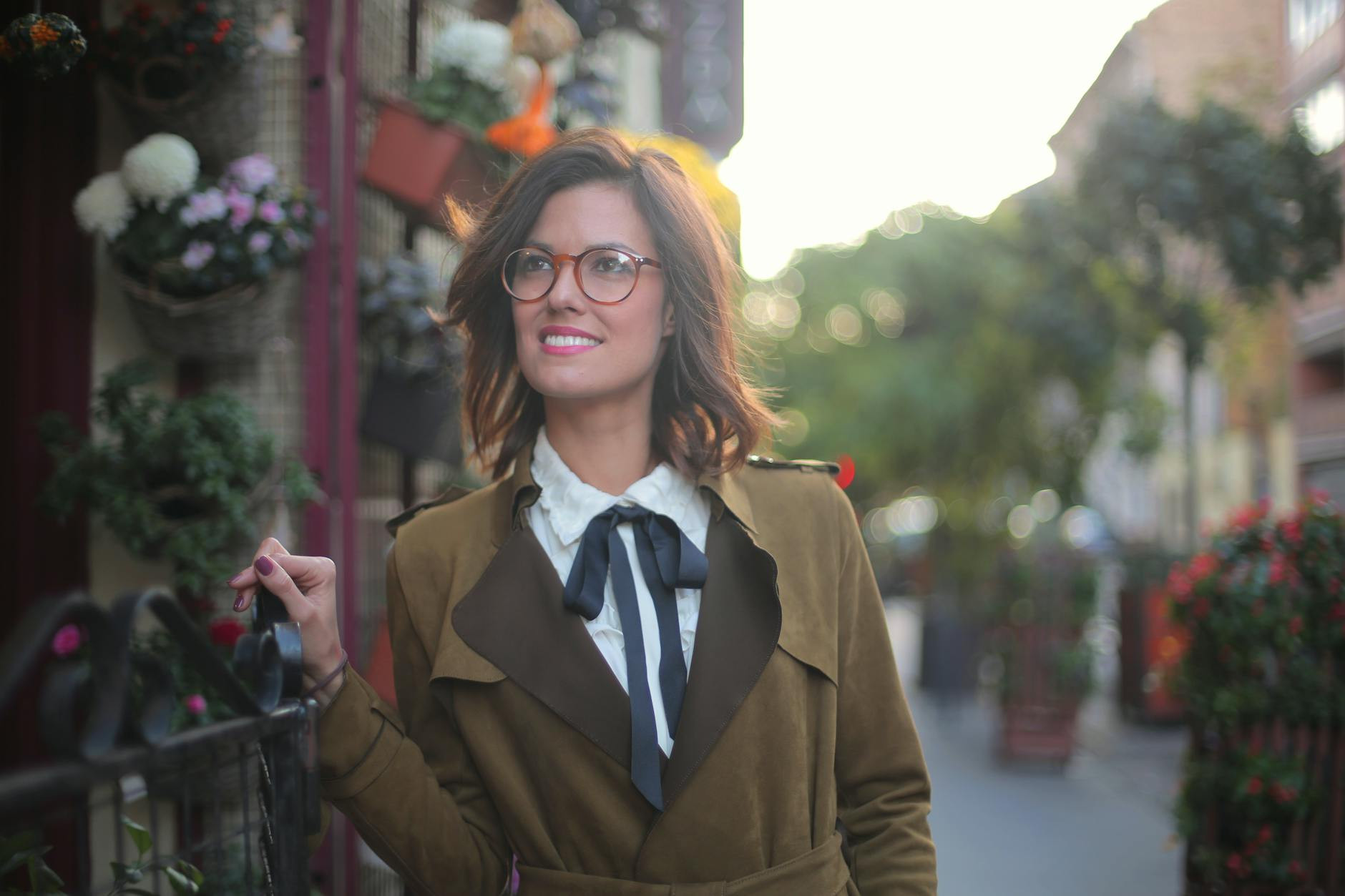 joyful stylish woman on street in city wearing round glasses