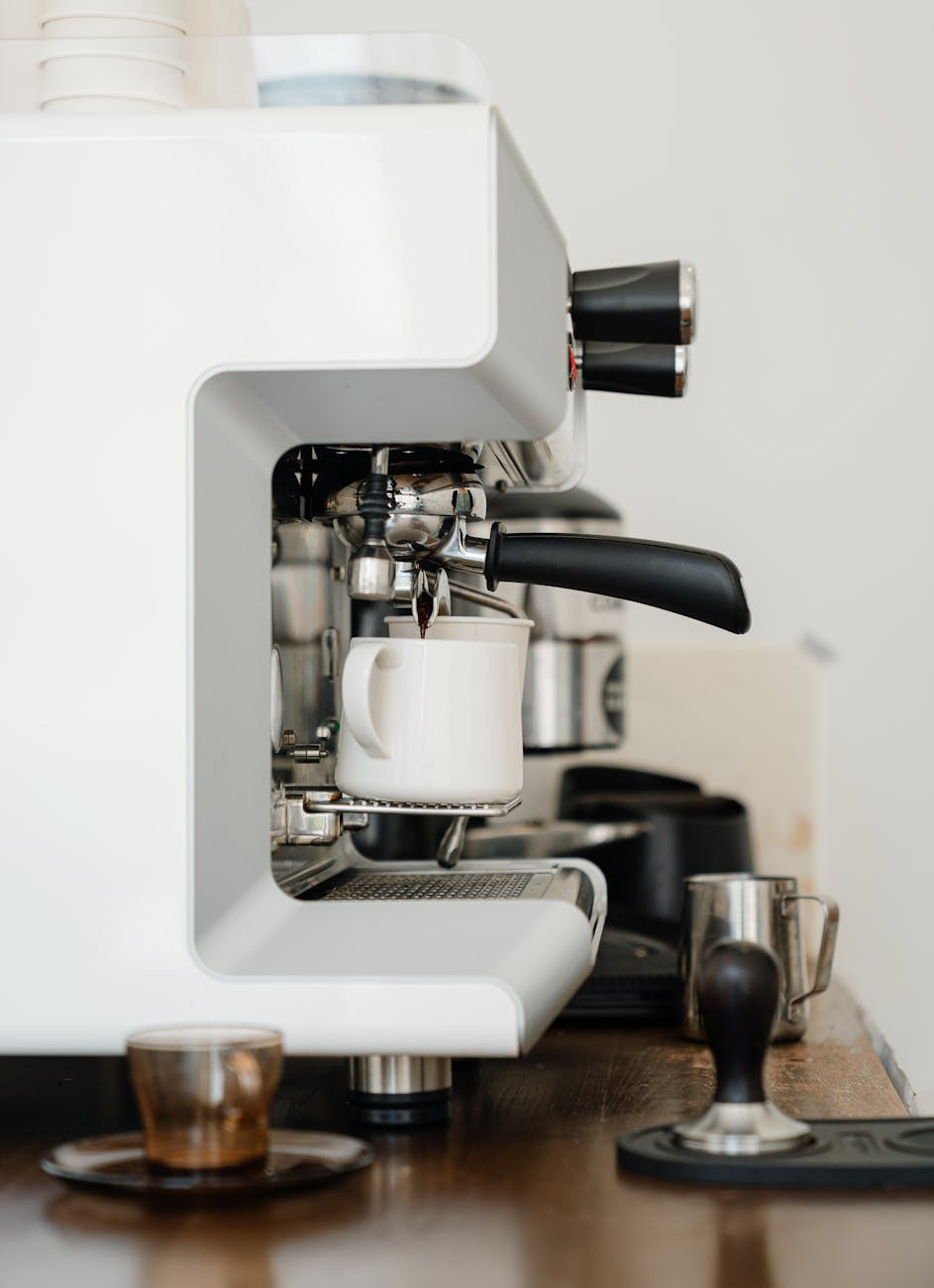 coffee machine pouring cappuccino into cup in modern cafe