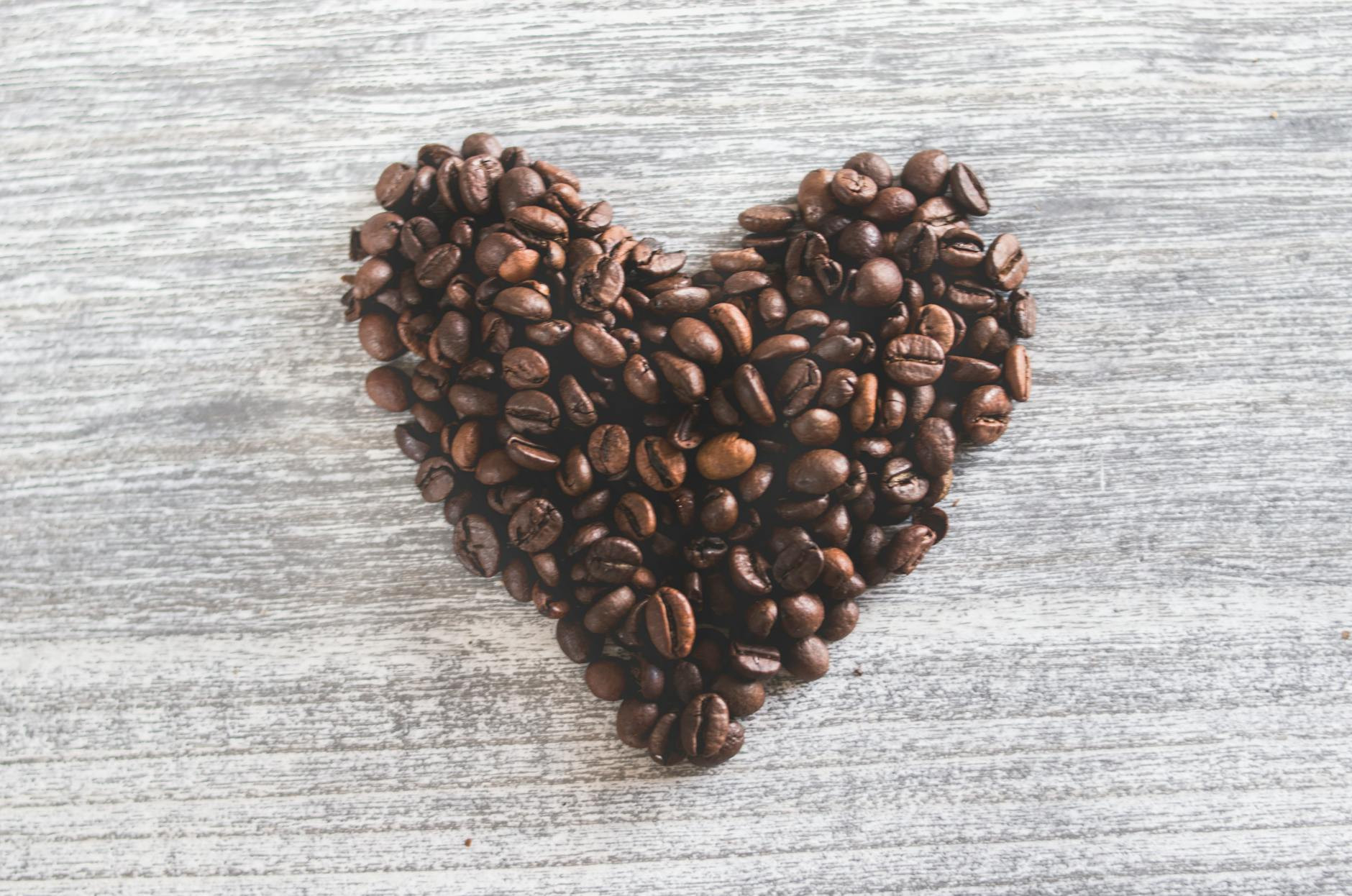 flat lay photo of heart shaped coffee beans to symbolize a coffee subscription box as a birthday gift idea for mom