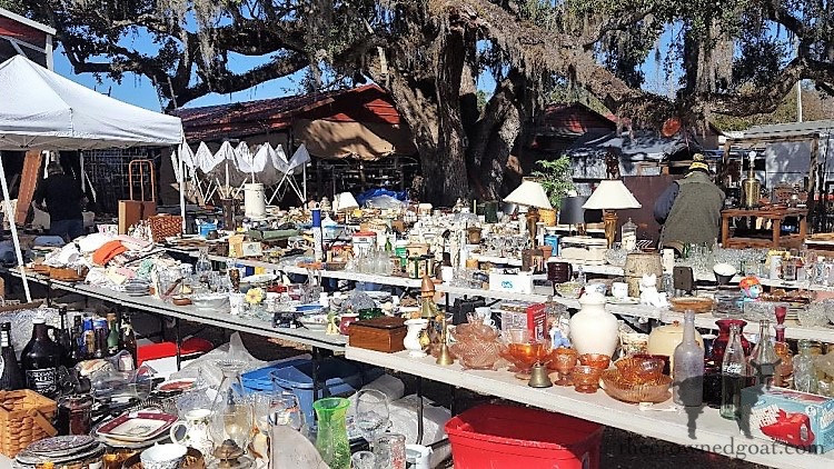 A close-up of vintage glassware and decorative items at an outdoor market, emphasizing the detailed craftsmanship and unique appeal of antique goods.