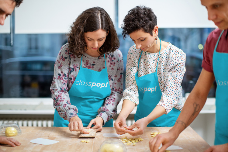 Wife learning new culinary skills in a cooking class, an interactive birthday gift idea (via Classpop!)