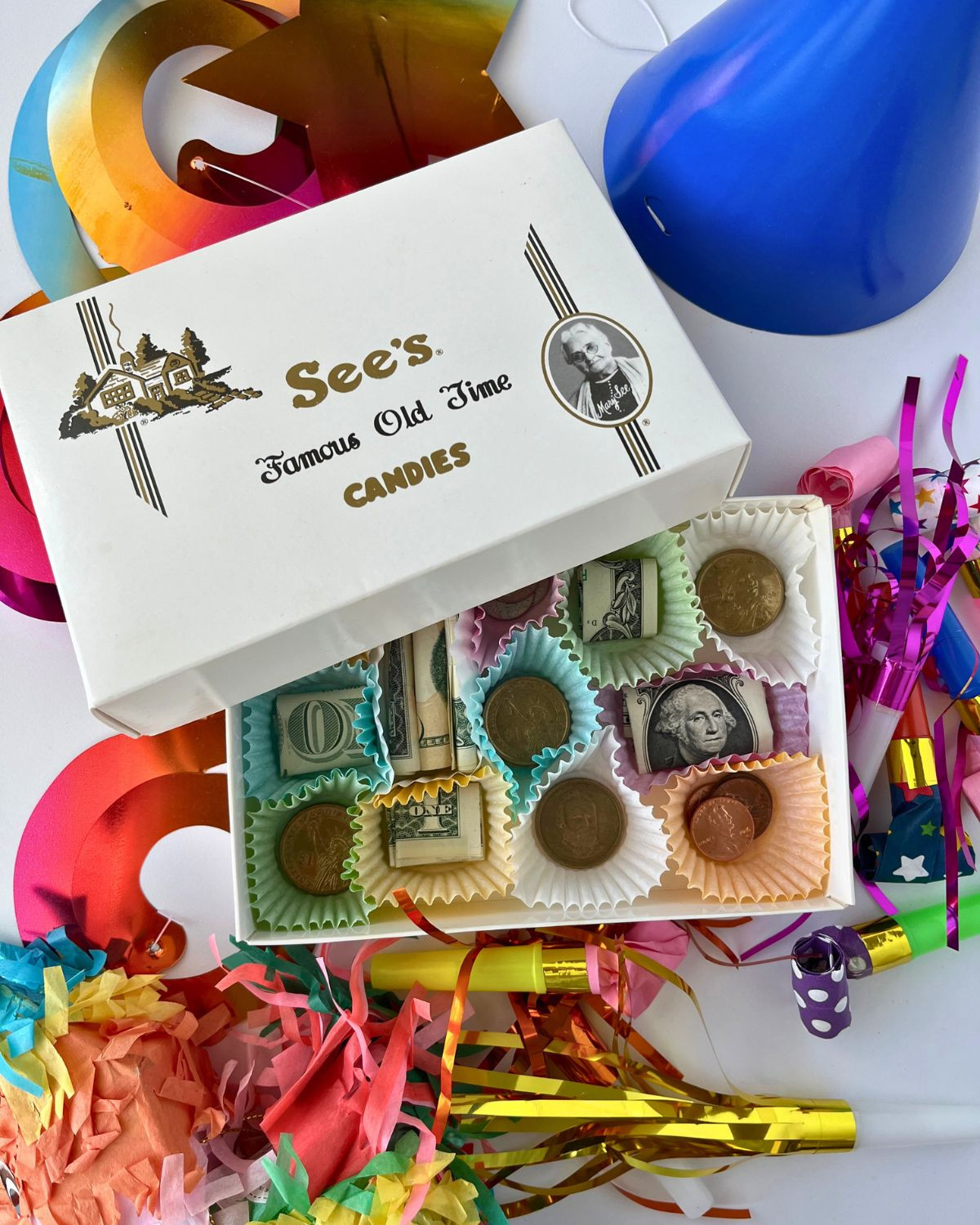 Open candy box revealing dollar bills and coins, creative money gift idea