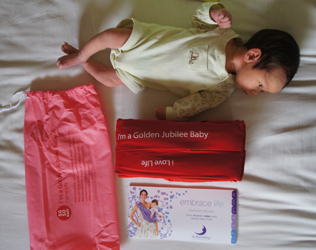 Red baby sling from BabaSling, a practical and loving baby gift