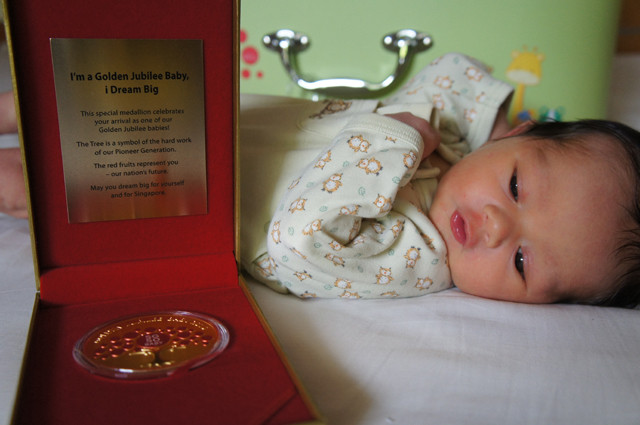 A shiny gold medallion, a commemorative baby gift