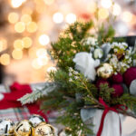 Small Christmas flower arrangement featuring foraged greenery, a faux rose, and yarn balls, perfect for a gift card, showcasing a handmade Christmas gift idea