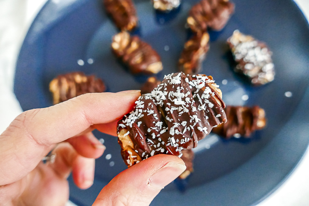 A plate of snickers bites, highlighting their date-based shape and resemblance to miniature Snickers bars.
