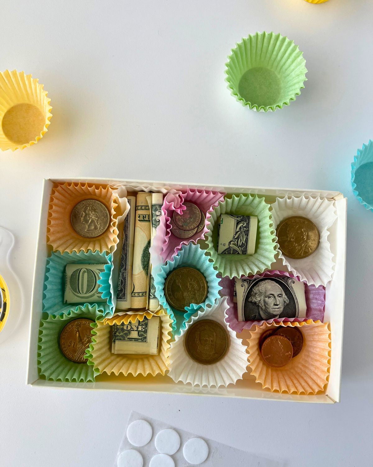 Close-up of paper liners filled with rolled and taped currency for a money gift box